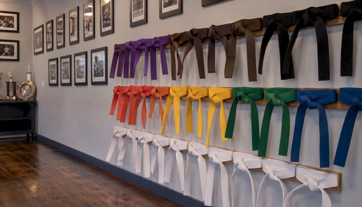 Dojo wall with female student belts and photos